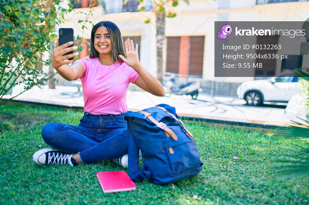 Young latin student girl smiling happy doing video call using smartphone at university campus.