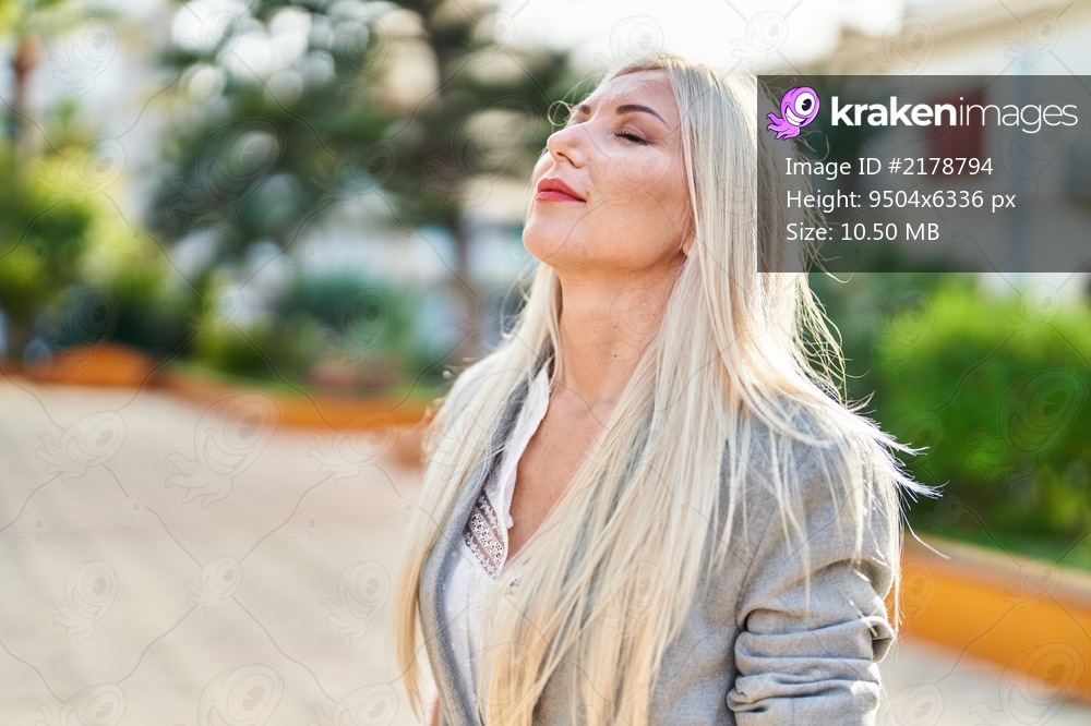 Young blonde woman smiling confident breathing at park