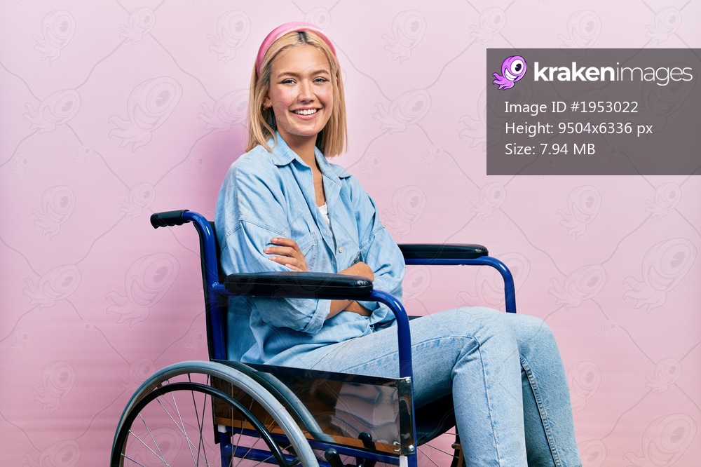 Beautiful blonde woman sitting on wheelchair happy face smiling with crossed arms looking at the camera. positive person. 