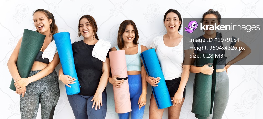 Group of women holding yoga mat standing over isolated background winking looking at the camera with sexy expression, cheerful and happy face. 