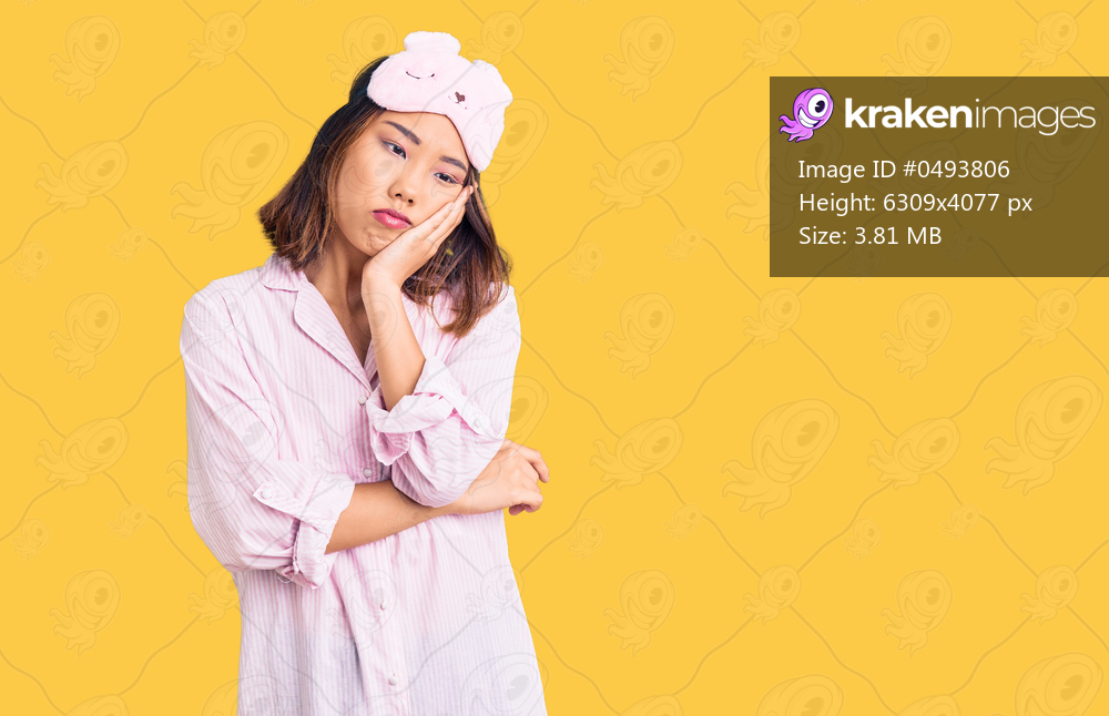 Young beautiful chinese girl wearing sleep mask and pajama thinking looking tired and bored with depression problems with crossed arms. 