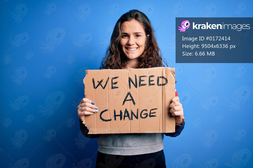 Young beautiful activist woman holding banner with change message over blue background with a happy face standing and smiling with a confident smile showing teeth