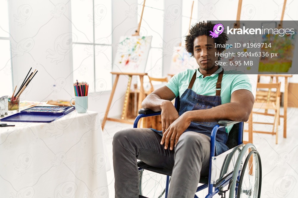 Young african american artist man sitting on wheelchair at art studio depressed and worry for distress, crying angry and afraid. sad expression. 