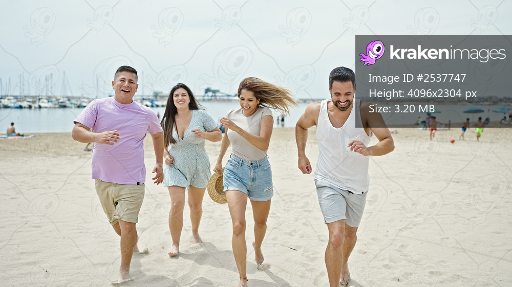 Group of people smiling confident running at beach