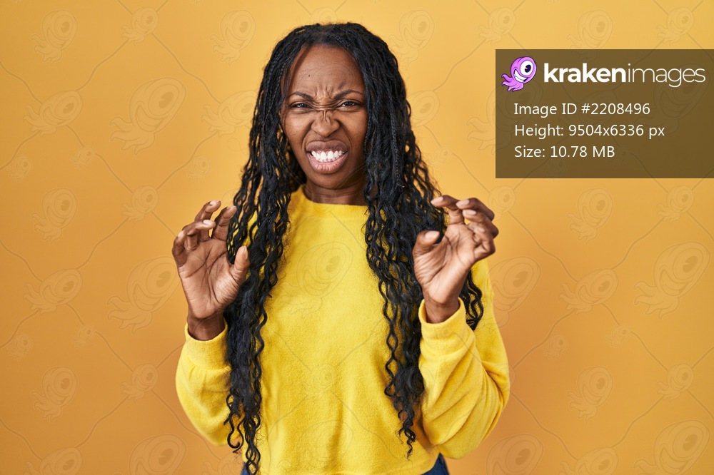 African woman standing over yellow background disgusted expression ...