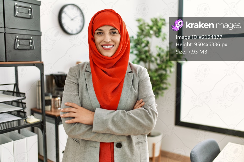 Young woman wearing arabic scarf standing with arms crossed gesture at office
