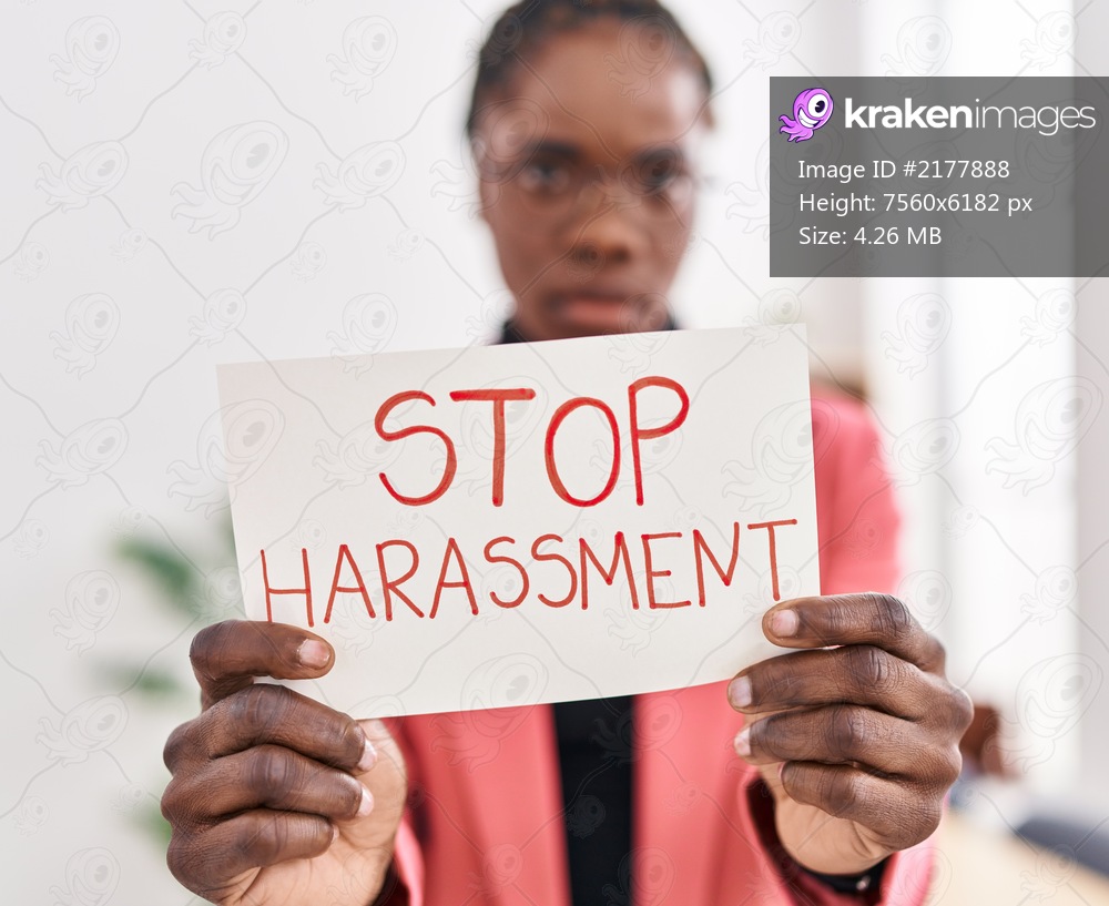 African american woman business worker holding stop harassement banner at office