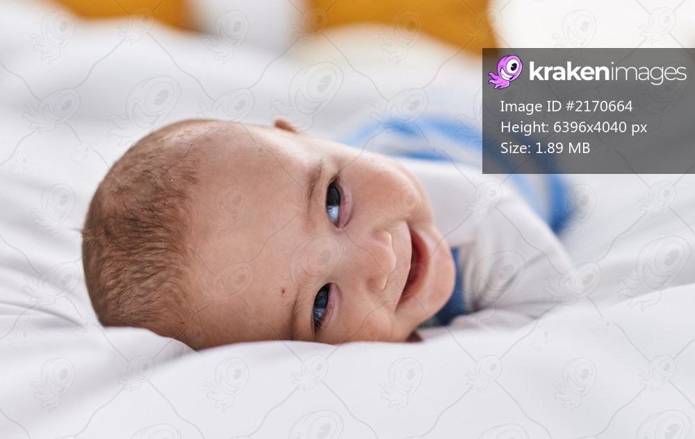 Adorable baby smiling confident lying on bed at bedroom