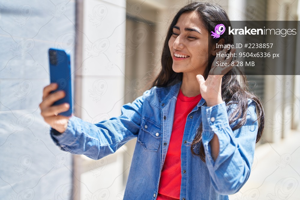 Young hispanic girl smiling confident having video call at street