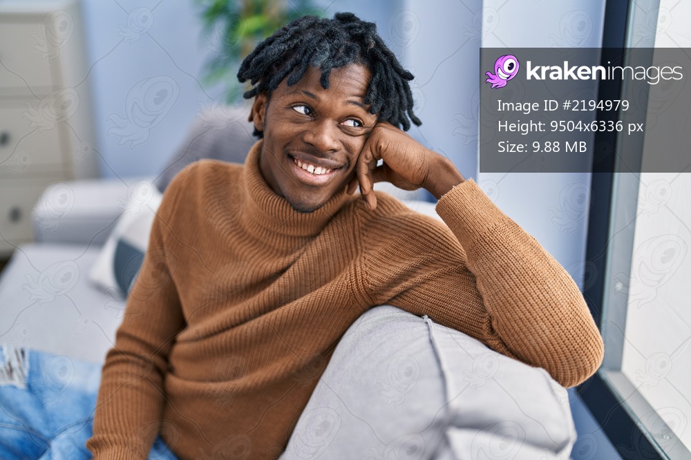 African american man smiling confident sitting on sofa at home