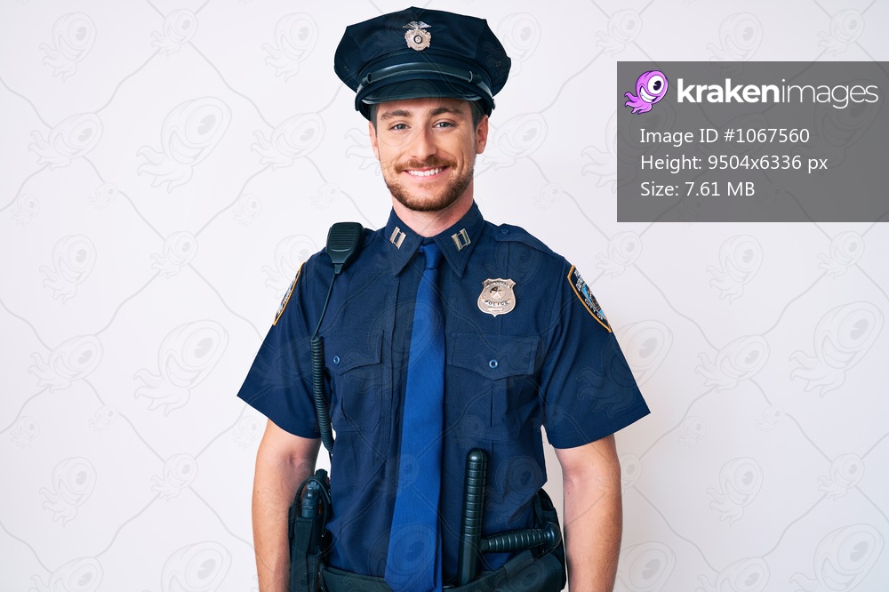 Young caucasian man wearing police uniform with a happy and cool smile on face. lucky person. 