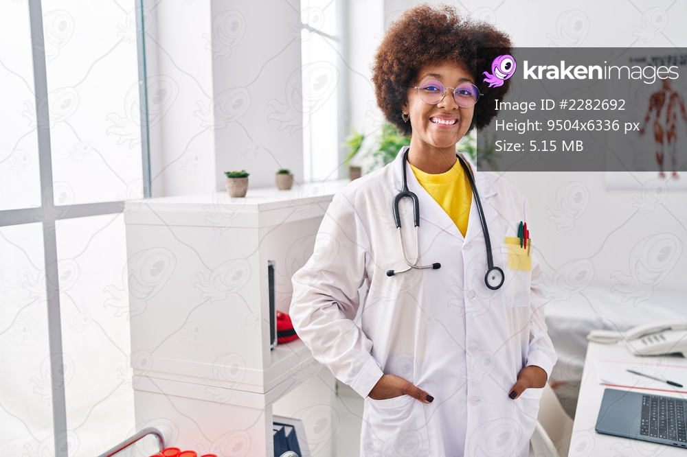 African american woman wearing doctor uniform smiling confident standing at clinic