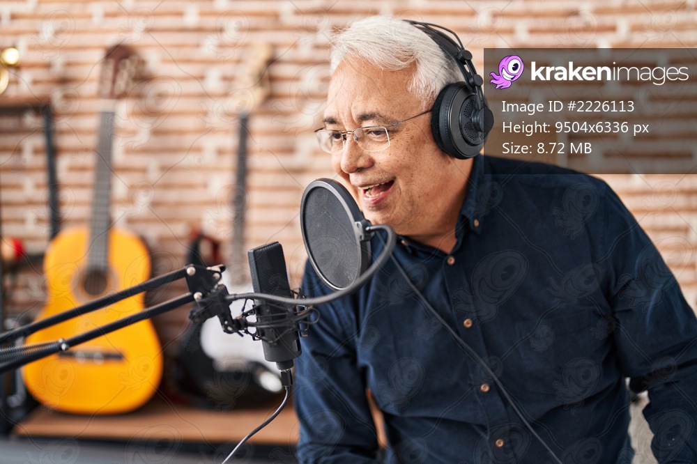 Senior man artist singing song at music studio