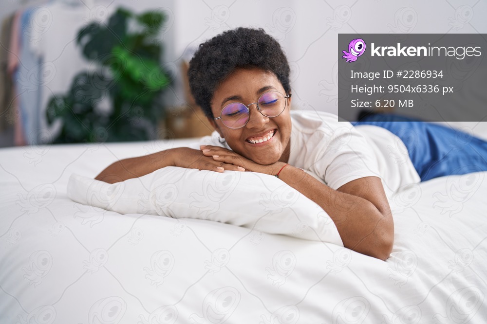 African american woman smiling confident lying on bed at bedroom