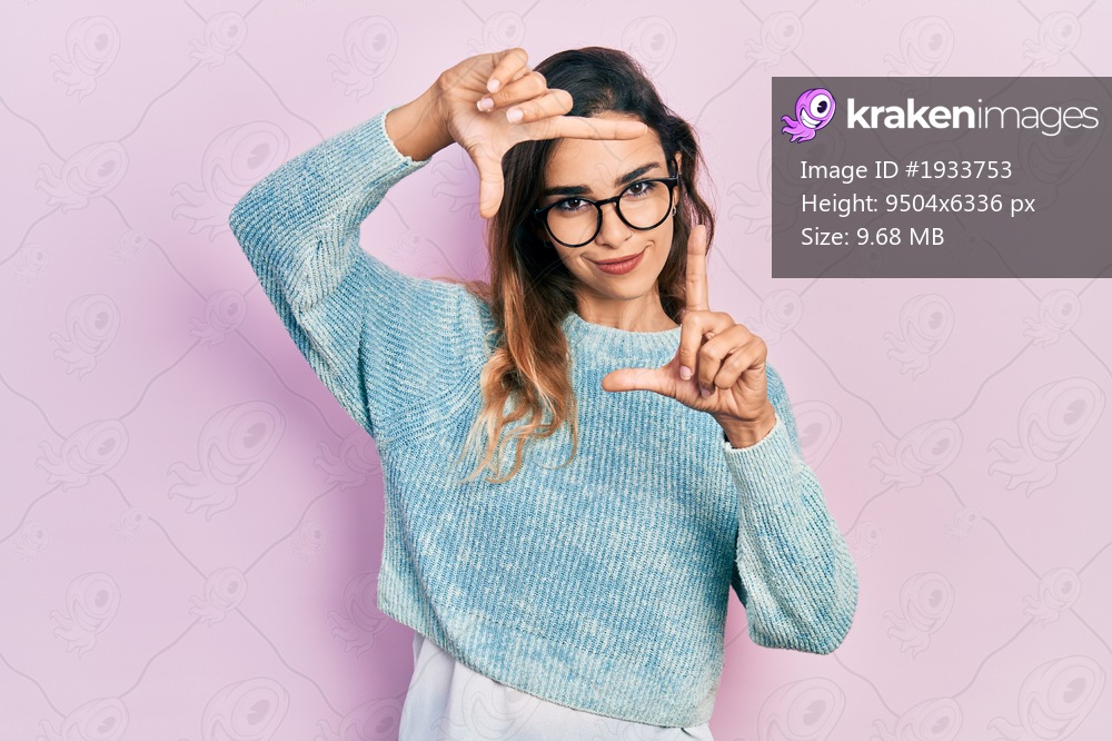 Young hispanic girl wearing casual clothes and glasses smiling making frame with hands and fingers with happy face. creativity and photography concept. 