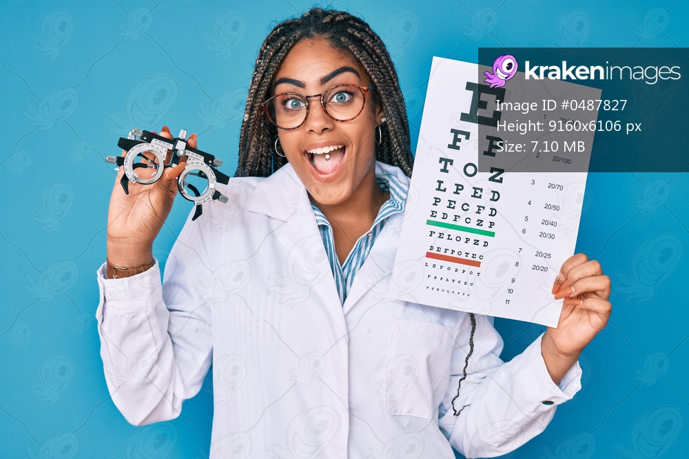 Young african american optician woman with braids holding optometry glasses and medical exam celebrating crazy and amazed for success with open eyes screaming excited. 