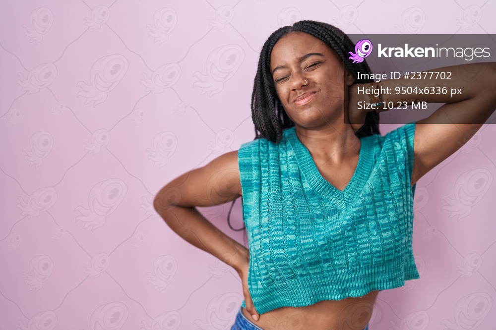 young-african-american-with-braids-standing-over-pink-background